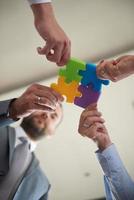 business people group assembling jigsaw puzzle photo