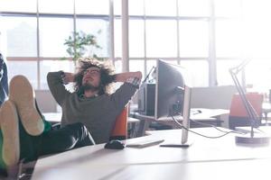 businessman sitting with legs on desk photo