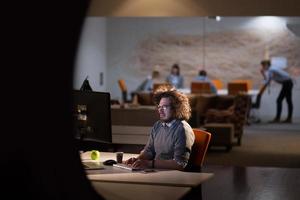 man working on computer in dark office photo