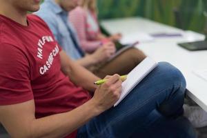 estudiante varón tomando notas en el aula foto