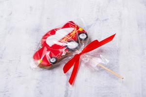 A closeup shot of a red car-shaped cookie on a stick photo