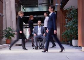 business man sitting in office chair, people group  passing by photo