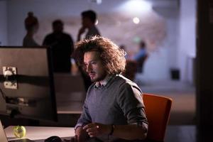 man working on computer in dark office photo