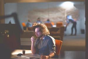 man working on computer in dark office photo