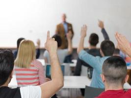 grupo de estudiantes levantan la mano en clase foto