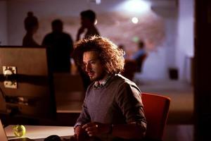 hombre trabajando en una computadora en una oficina oscura foto