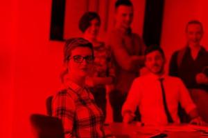 portrait of young business woman at office with team on meeting in background photo