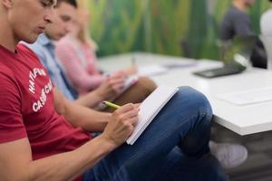 male student taking notes in classroom photo