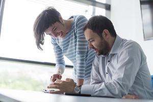 Two Business People Working With Tablet in startup office photo