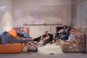 software developers sleeping on sofa in creative startup office photo