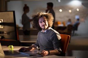 man working on computer in dark office photo