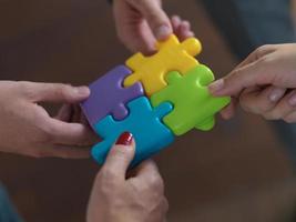 business people group assembling jigsaw puzzle photo