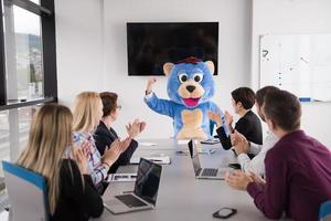 jefe vestido como oso divirtiéndose con gente de negocios en una oficina de moda foto