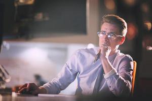 man working on computer in dark office photo