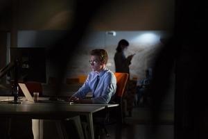 man working on computer in dark office photo