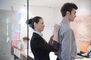 young couple signing contract documents on partners back photo