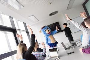 boss dresed as bear having fun with business people in trendy office photo