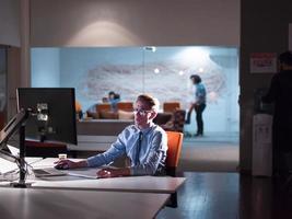 man working on computer in dark office photo