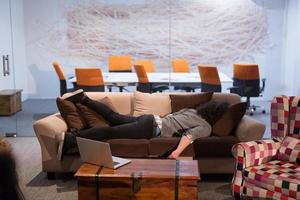 man sleeping on a sofa  in a creative office photo