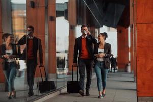 Business man and business woman talking and holding luggage traveling on a business trip photo