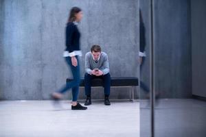 businessman using mobile phone while sitting on the bench photo