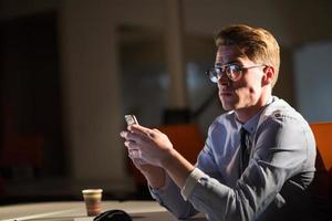 man using mobile phone in dark office photo
