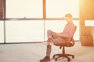 young casual businessman using mobile phone on construction site photo