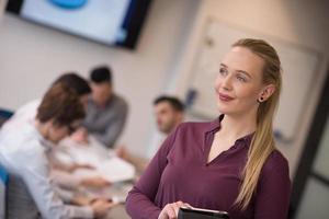 empresaria rubia que trabaja en la tableta en la oficina foto