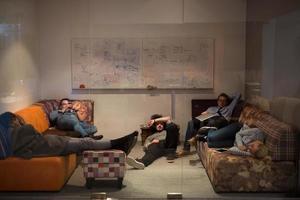 software developers sleeping on sofa in creative startup office photo