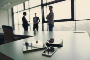 close up of tablet, business people on meeting in background photo