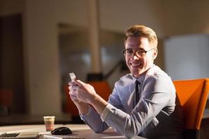 man using mobile phone in dark office photo