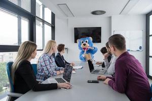 boss dresed as bear having fun with business people in trendy office photo