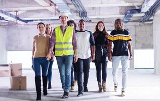 jóvenes empresarios multiétnicos caminando por una oficina inacabada foto