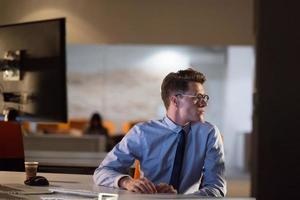 man working on computer in dark office photo