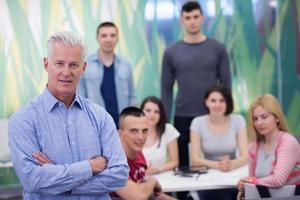 retrato de profesor con grupo de estudiantes en segundo plano. foto