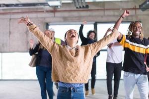 young multiethnic business people dancing in unfinished startup office photo