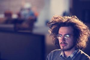 man working on computer in dark office photo