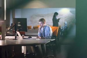 man working on computer in dark office photo