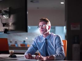 man working on computer in dark office photo