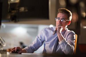 man working on computer in dark office photo