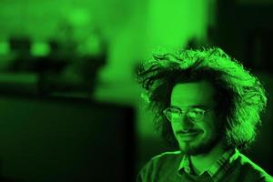 man working on computer in dark office photo