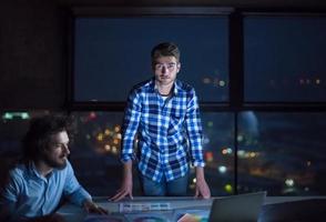 business people on construction site  in new startup office at night photo