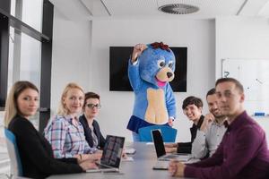 boss dresed as bear having fun with business people in trendy office photo