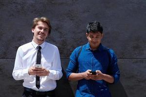 hombres de negocios de inicio multiétnicos casuales que usan teléfonos móviles foto