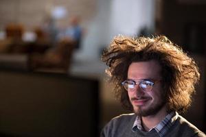 man working on computer in dark office photo