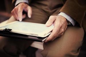 Closeup of mature hands holding tablet. photo