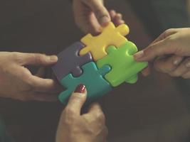 business people group assembling jigsaw puzzle photo