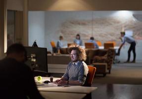 man working on computer in dark office photo