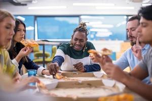 equipo de negocios multiétnico comiendo pizza foto