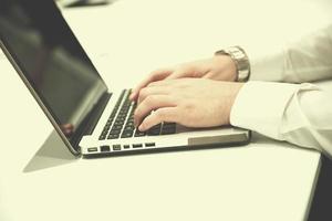 hands typing on laptop at meeting photo